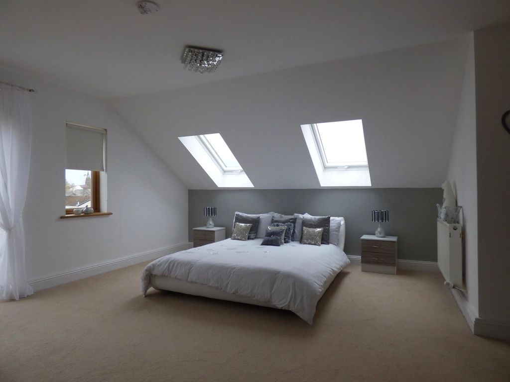 A guest room with a large bed and soft lighting